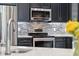 Modern kitchen features stainless steel appliances, granite countertops, and sleek dark cabinetry at 10146 Pointview Ct, Orlando, FL 32836