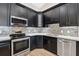Well-lit kitchen has dark cabinets, stainless steel appliances, and a stylish backsplash at 10146 Pointview Ct, Orlando, FL 32836