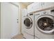 Laundry room with modern washer and dryer, and white cabinets for storage at 10146 Pointview Ct, Orlando, FL 32836