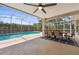 Covered outdoor patio with a dining area overlooking a sparkling blue pool at 10146 Pointview Ct, Orlando, FL 32836