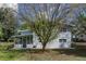 Expansive backyard with a covered patio and mature tree, providing shade and privacy at 11 S University Cir, Deland, FL 32724