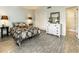 A cozy bedroom featuring a queen bed, white dresser with decorative mirror and a bathroom entrance at 11 S University Cir, Deland, FL 32724