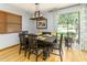 Cozy dining room showcasing hardwood floors, a modern chandelier, and large windows at 11 S University Cir, Deland, FL 32724