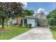 Charming single-story home featuring a well-manicured front yard and a convenient covered carport at 11 S University Cir, Deland, FL 32724