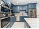 Modern kitchen with stainless steel appliances, stylish blue cabinetry and a sleek tile backsplash at 11 S University Cir, Deland, FL 32724