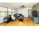Comfortable living room featuring hardwood floors, a ceiling fan, and large windows at 11 S University Cir, Deland, FL 32724