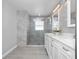Modern bathroom featuring glass enclosed shower, double sinks, white cabinets, and gray toned walls at 11218 Rouse Run Cir, Orlando, FL 32817