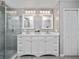 Updated bathroom features double vanity, glass enclosed shower, modern fixtures, and a linen closet at 11218 Rouse Run Cir, Orlando, FL 32817