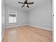 This bedroom has wood laminate flooring, a ceiling fan, and a window offering ample natural light at 11218 Rouse Run Cir, Orlando, FL 32817