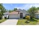 Inviting one-story home featuring a well-manicured lawn, mature trees, and a two-car garage at 11218 Rouse Run Cir, Orlando, FL 32817