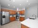 Stylish kitchen featuring stainless appliances, tile flooring, wood cabinetry, and quartz countertops at 11218 Rouse Run Cir, Orlando, FL 32817