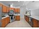 Open kitchen with stainless steel appliances, quartz counters, tile backsplash and adjacent view to the backyard at 11218 Rouse Run Cir, Orlando, FL 32817