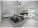 Staged main bedroom with ceiling fan, neutral colors, ensuite bathroom, and light wood flooring at 11218 Rouse Run Cir, Orlando, FL 32817