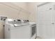 Convenient laundry room with a washer, dryer, and storage shelf at 11316 Rapallo Ln, Windermere, FL 34786