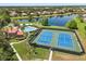 This aerial view highlights tennis courts, a pool, and a serene lake at 11316 Rapallo Ln, Windermere, FL 34786