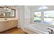Bright bathroom featuring a soaking tub with jets, a large vanity, and a window overlooking the front yard at 1254 Shelter Rock Rd, Orlando, FL 32835