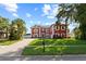 Charming two-story home with a red and white facade, complemented by lush greenery and a blue sky at 1254 Shelter Rock Rd, Orlando, FL 32835