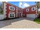 Striking two-story red house with white trim, attached garage, and brick paved driveway at 1254 Shelter Rock Rd, Orlando, FL 32835