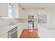 Bright kitchen with stainless steel appliances, white cabinetry, granite counters, and tile backsplash at 1254 Shelter Rock Rd, Orlando, FL 32835