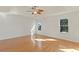 Primary bedroom featuring a tray ceiling, wood floors, and two windows with tree views at 1254 Shelter Rock Rd, Orlando, FL 32835