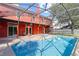 Enclosed pool area with spa, covered seating, and steps leading down to pool at 1254 Shelter Rock Rd, Orlando, FL 32835