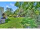 Expansive backyard featuring lush green grass, mature trees, and a charming playground area at 12618 Lakebrook Dr, Orlando, FL 32828