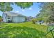 Spacious backyard with a well-maintained lawn, patio seating, mature trees, and play structure at 12618 Lakebrook Dr, Orlando, FL 32828