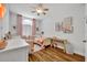 Charming bedroom with twin beds, wood floors, and whimsical decor, bathed in natural light at 12618 Lakebrook Dr, Orlando, FL 32828