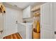 Functional laundry room with white cabinets, washer, dryer, and storage shelves, optimized for efficiency at 12618 Lakebrook Dr, Orlando, FL 32828