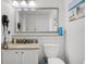 Bright bathroom featuring a granite countertop, framed mirror, and a convenient toilet and sink combo at 13415 Blue Heron Beach Dr # 1503, Orlando, FL 32821