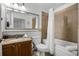 Well-lit bathroom featuring a granite vanity, a bathtub and shower, and convenient toiletry storage at 13415 Blue Heron Beach Dr # 1503, Orlando, FL 32821