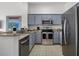 Updated kitchen features stainless steel appliances, granite countertops, and blue cabinets at 13415 Blue Heron Beach Dr # 1503, Orlando, FL 32821