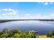 Scenic view of a vast lake with lush shoreline trees, a charming dock, and an endless blue sky at 13415 Blue Heron Beach Dr # 1503, Orlando, FL 32821