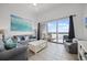 Bright living room with tile floors, comfortable seating, and a sliding door to a waterfront balcony at 13415 Blue Heron Beach Dr # 1503, Orlando, FL 32821