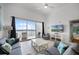 Cozy living room with balcony access, tile flooring, comfortable couches, and a TV at 13415 Blue Heron Beach Dr # 1503, Orlando, FL 32821