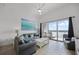 Inviting living room with comfortable seating and a large sliding glass door to the balcony and waterfront view at 13415 Blue Heron Beach Dr # 1503, Orlando, FL 32821