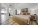 A bright main bedroom features a bathroom en suite, light wood floors, and a large painting at 13415 Blue Heron Beach Dr # 1503, Orlando, FL 32821