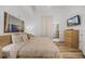 Bright main bedroom with hard wood floors, a large bed with ornate bedspread, and a dresser with a tv at 13415 Blue Heron Beach Dr # 1503, Orlando, FL 32821