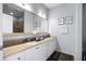 Well-lit bathroom with dual sinks, granite counters, white cabinetry, and a large mirror at 13427 Blue Heron Beach Dr # 2003, Orlando, FL 32821