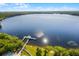 An aerial view of the lake, pier, and surrounding trees and foliage at 13427 Blue Heron Beach Dr # 2003, Orlando, FL 32821