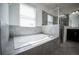 Modern bathroom features a soaking tub, glass-enclosed shower, and tiled walls at 14572 Black Quill Dr, Winter Garden, FL 34787