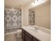 Well-lit bathroom featuring a vanity with a sink, tiled flooring, and a shower with a decorative curtain at 14572 Black Quill Dr, Winter Garden, FL 34787