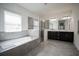 Bright bathroom featuring a soaking tub, glass-enclosed shower, and dual sinks at 14572 Black Quill Dr, Winter Garden, FL 34787