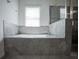 Bathroom with a luxurious tiled tub and a window at 14572 Black Quill Dr, Winter Garden, FL 34787