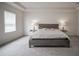 Bright bedroom with carpet flooring, a modern headboard, side tables and lamps, and white walls at 14572 Black Quill Dr, Winter Garden, FL 34787