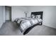 Modern bedroom features a black bed, carpeted floors, a lamp, and decor elements creating a cozy and relaxing space at 14572 Black Quill Dr, Winter Garden, FL 34787