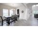 Open dining area features a modern chandelier, neutral decor, and natural light from two windows at 14572 Black Quill Dr, Winter Garden, FL 34787