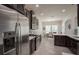 Well-lit kitchen featuring stainless steel appliances, dark wood cabinets, and a tiled backsplash at 14572 Black Quill Dr, Winter Garden, FL 34787