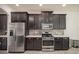 Kitchen features stainless steel appliances, dark cabinets, light countertops, and tiled backsplash at 14572 Black Quill Dr, Winter Garden, FL 34787