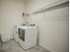 Bright laundry room featuring modern, white appliances and wire shelving for storage at 14572 Black Quill Dr, Winter Garden, FL 34787